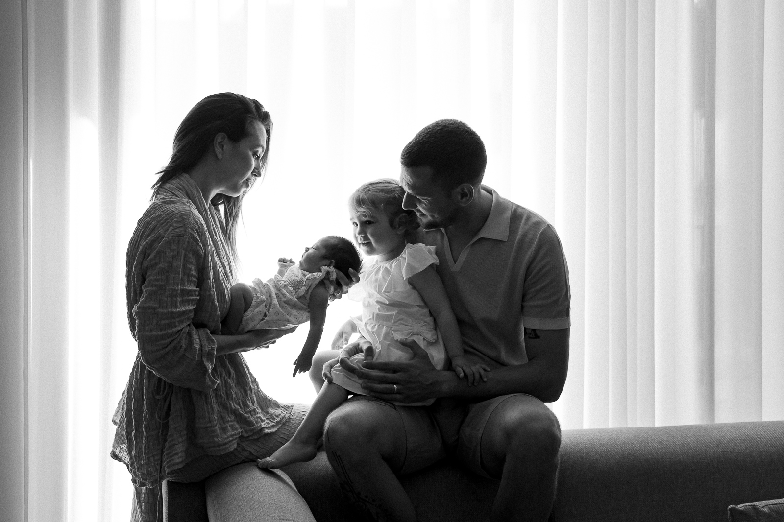 obitelj gleda novorođenu bebu u svom dnevnom boravku