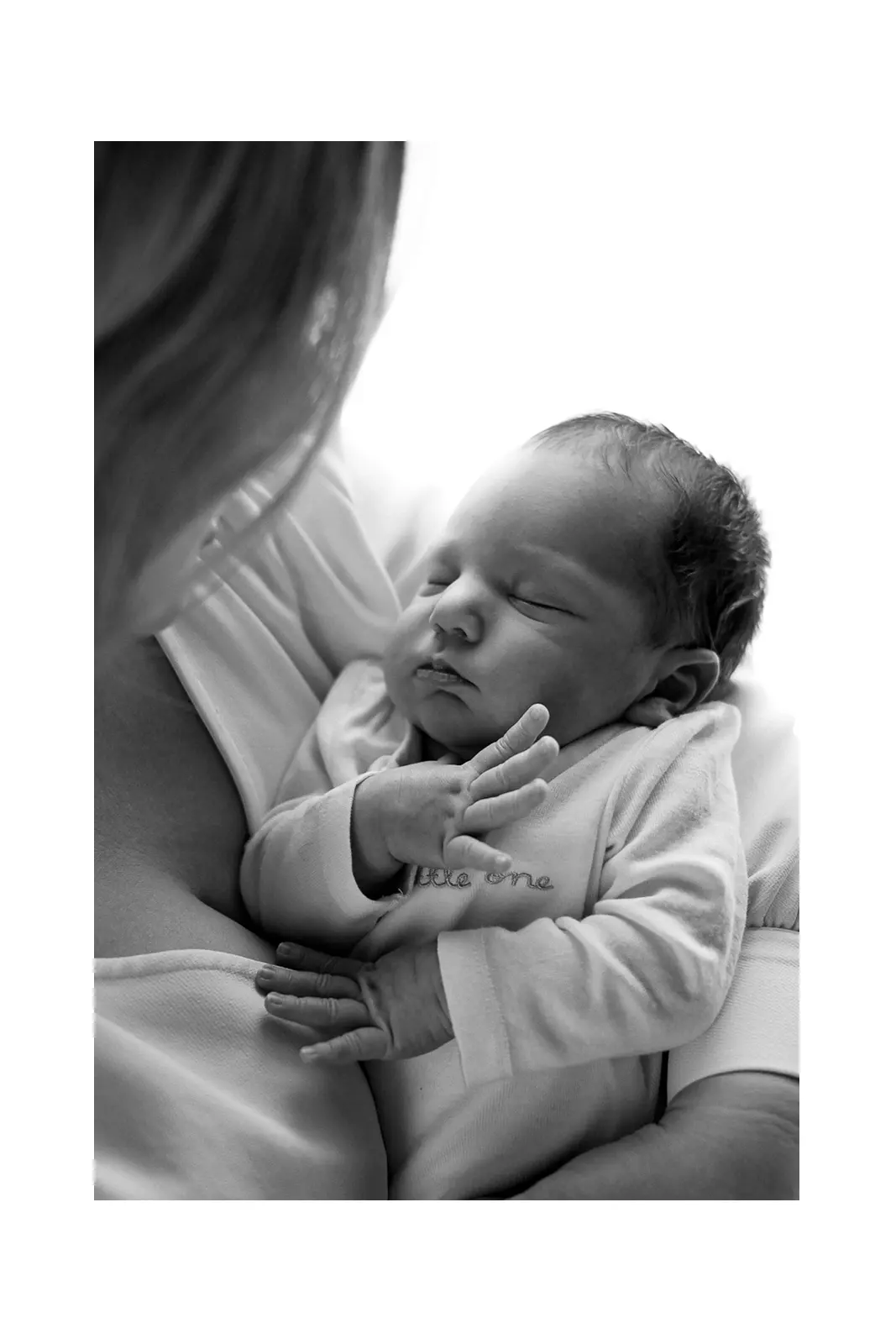 Mama drži novorođenu bebu u naručju