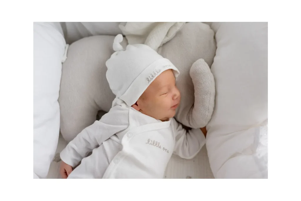 Beba spava u krevetiću na jastuku u obliku slonića