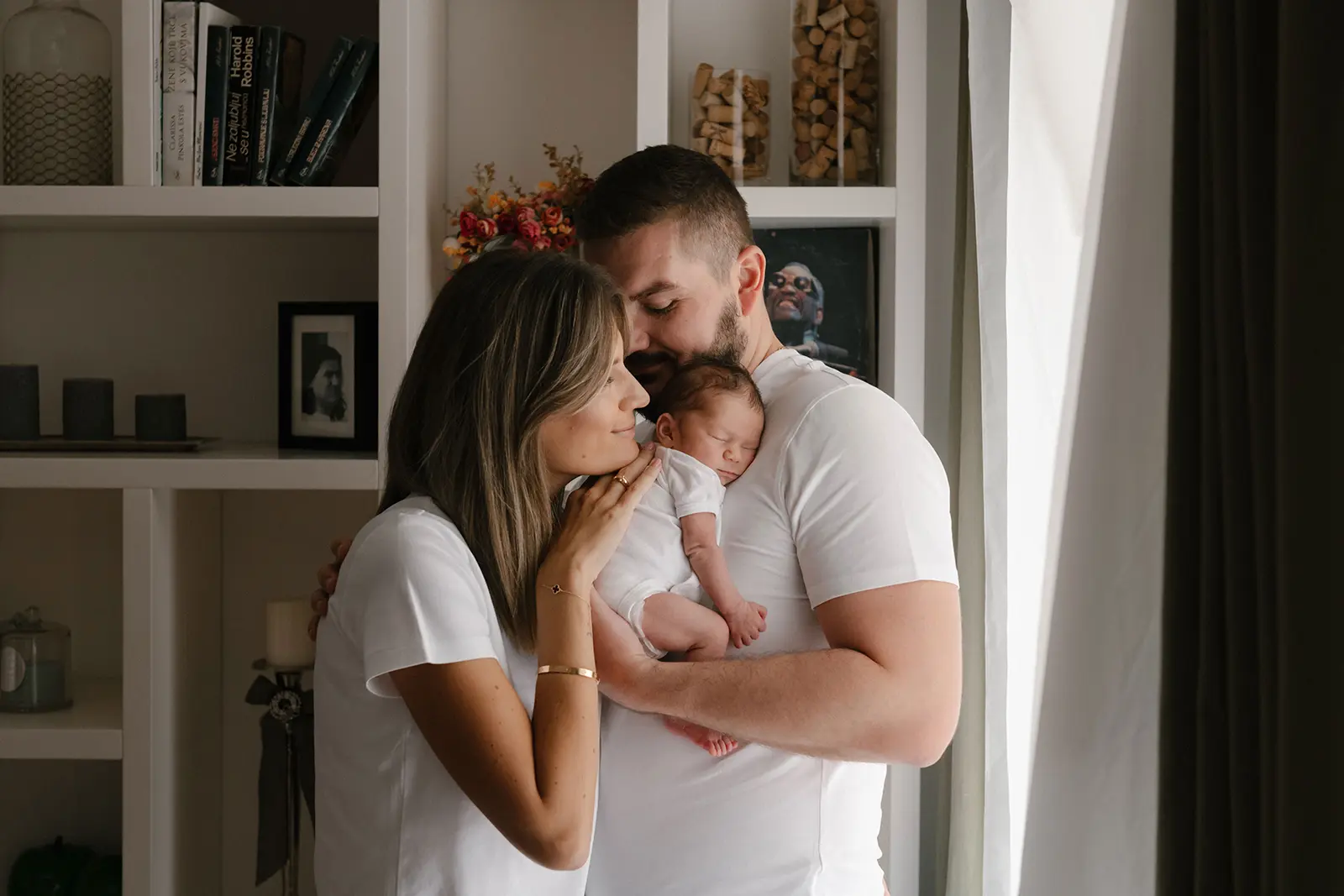 Mama i tata grle novorođenu bebu.